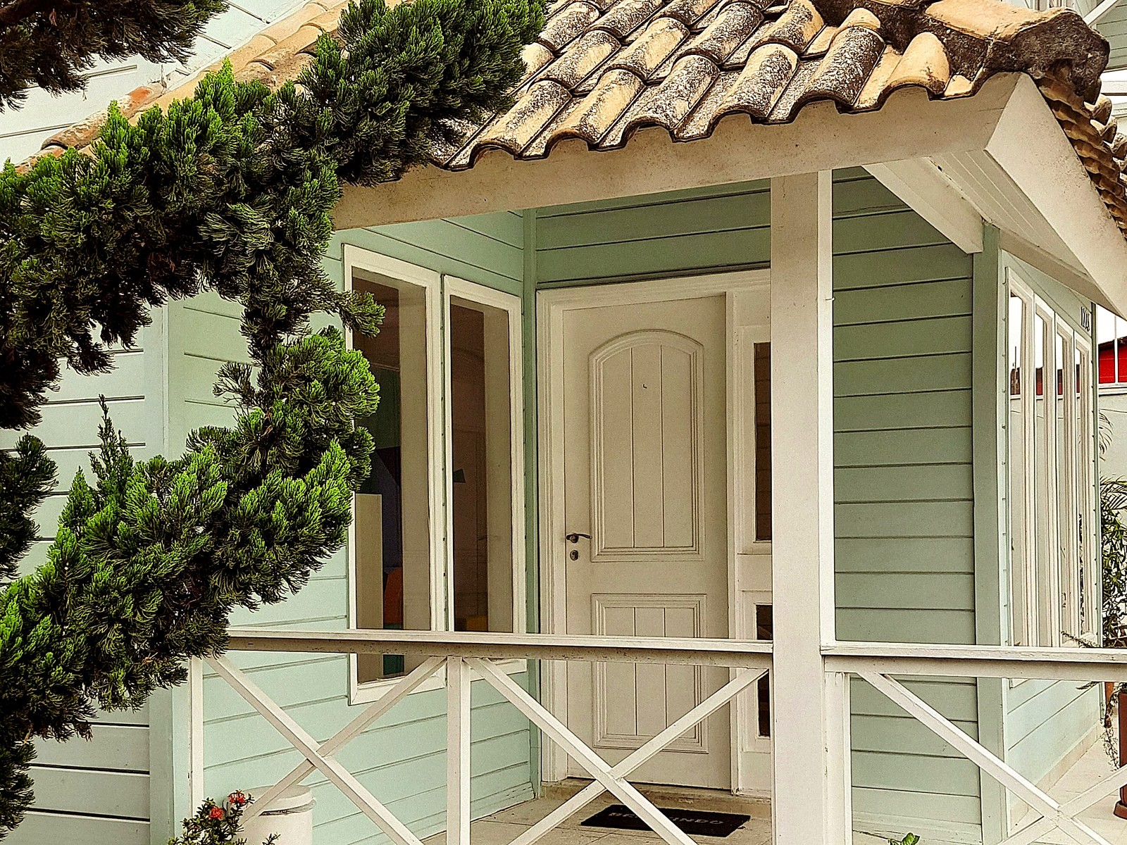 Varanda com telhado de telha e porta de madeira